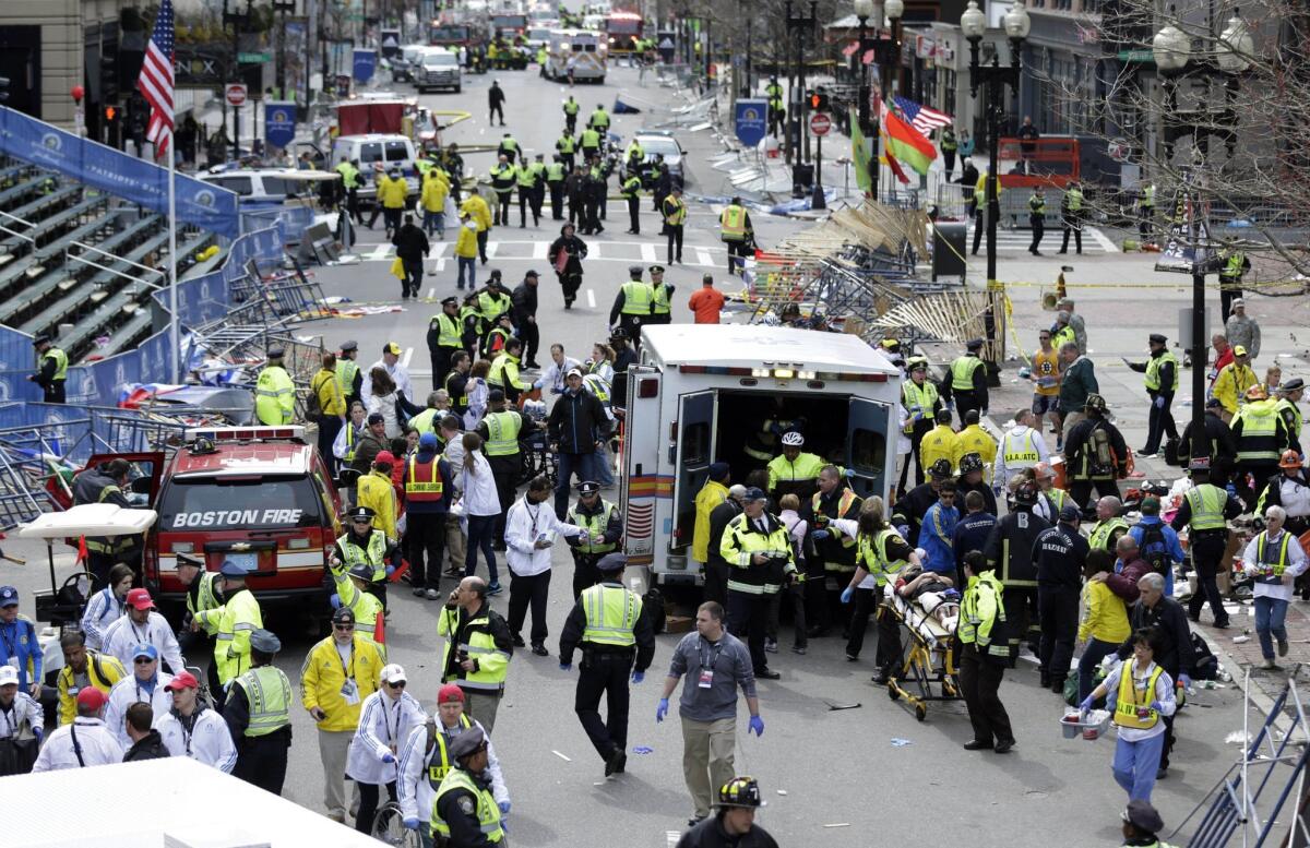 Medical workers aid injured people after a pair of explosions near the finish line of the 2013 Boston Marathon.