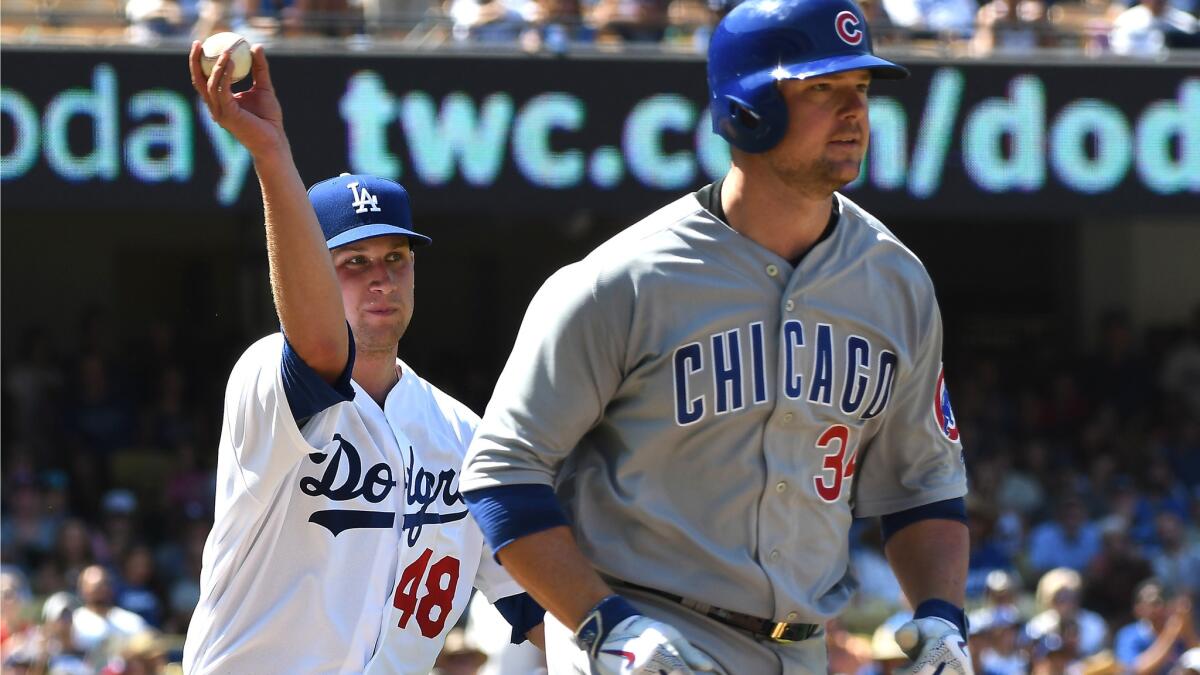 Dodgers pitcher Brock Stewart throws to first base to put out Cubs pitcher Jon Lester after he bunted Sunday.