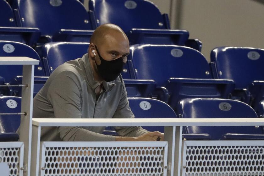 FILE - In this July 14, 2020, file photo, Miami Marlins CEO Derek Jeter watches the baseball team's practice in Miami. Jeter, who knows all about games in an empty ballpark, says success this season will require adapting to the absence of fans. (AP Photo/Wilfredo Lee, File)