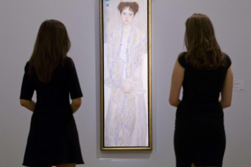 Two employees of Sotheby's auction house pose by a portrait of Gertrud Loew (Gertha Felsovanyi) by Austrian artist Gustav Klimt painted in 1902.