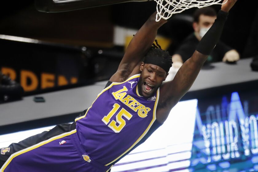 Los Angeles Lakers' Montrezl Harrell hangs from the rim after a dunk during the second half.