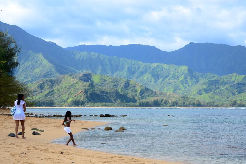 A bather dips a toe into the tempting waters of Hanalei, on the north shore of Kauai, Hawaii.