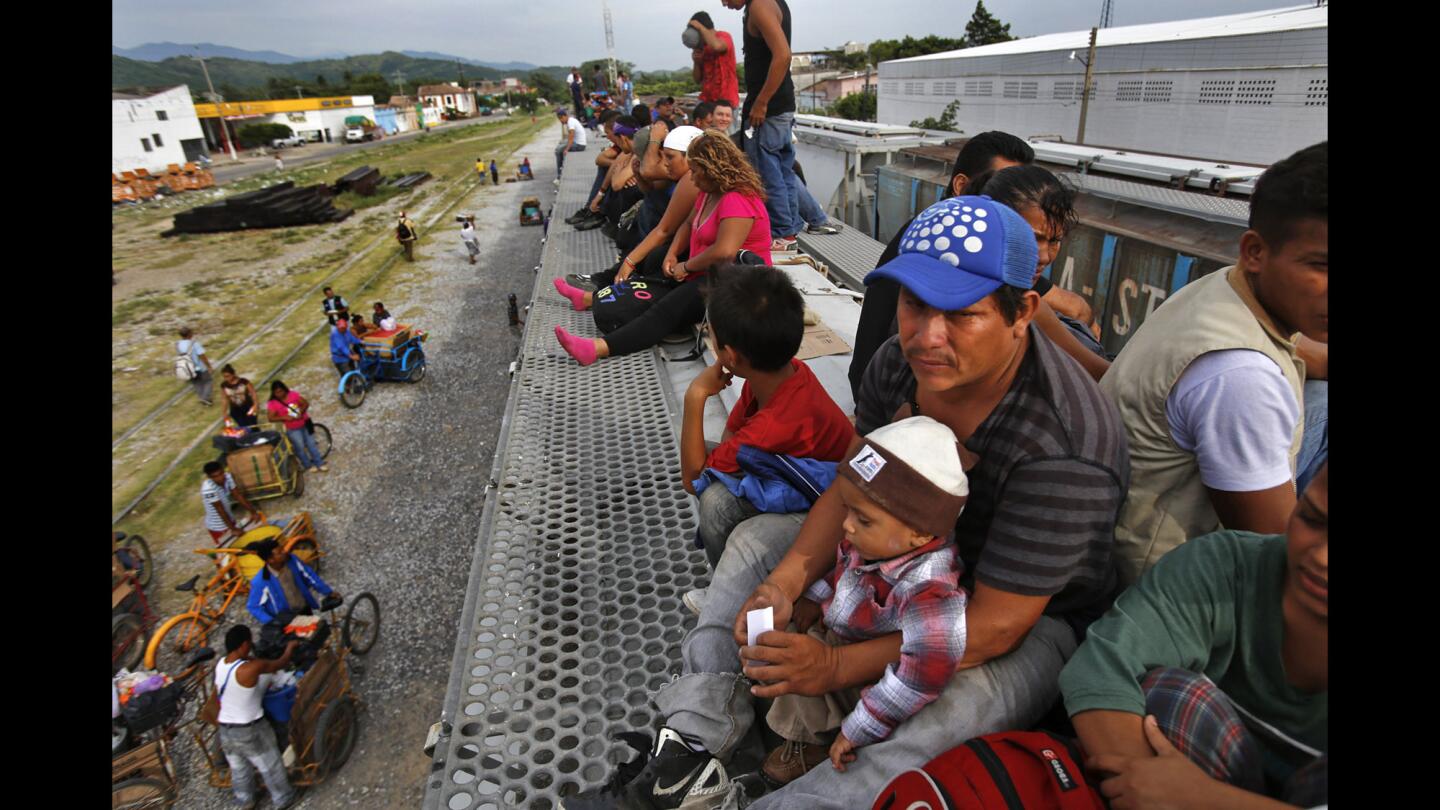 Eric Castellanos holds his 2-year-old son, Steven, on the roof of the freight train he hopes will take the family to a better life in the United States. Castellanos is from Escuintla, an impoverished and gang-ridden city on Guatemala's coastal plain.