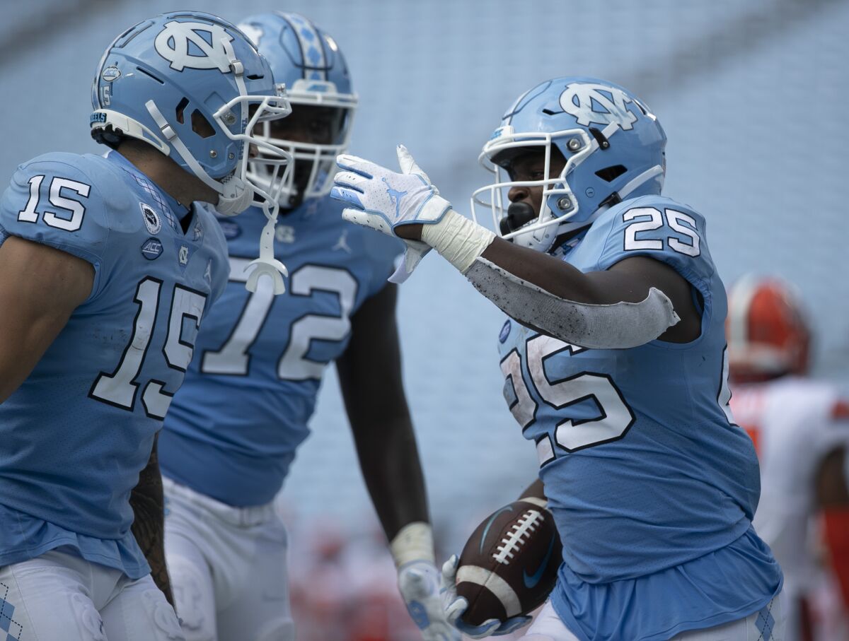 North Carolina's Javonte Williams (25) celebrates with teammates after scoring a touchdown in the fourth quarter of an NCAA college football game against Syracuse on Saturday, Sept. 12, 2020, in Chapel Hill, N.C. (Robert Willett/The News & Observer via AP, Pool)