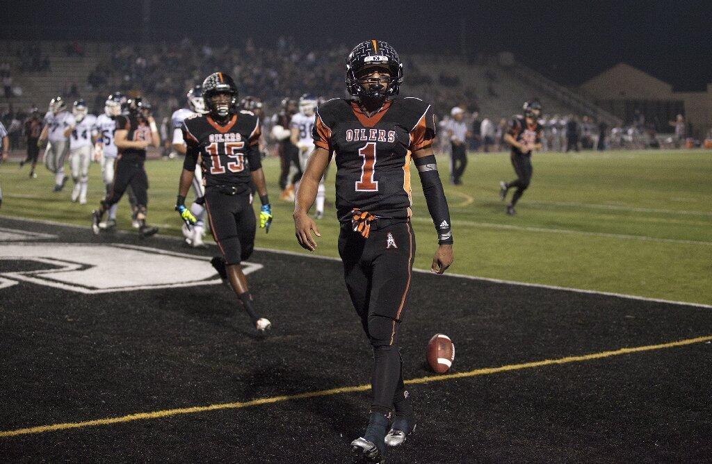 Huntington Beach's Kai Ross struts through the end zone after scoring a touchdown against Newport Harbor during a game on Friday.