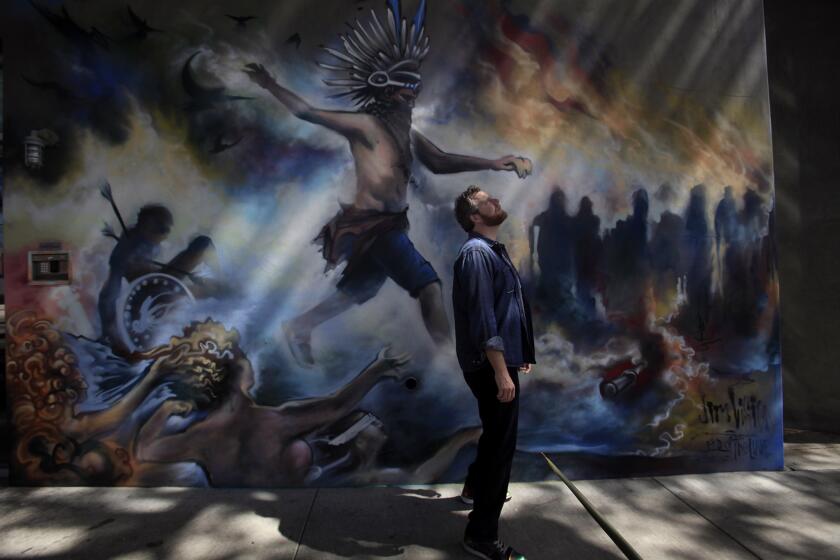 Oliver Luckett, cofounder and chief executive of tech start-up theAudience, stands in front of a mural painted by street artist Jim Rockwell, a.k.a. Jim Vision, on one of his offices in Los Angeles.