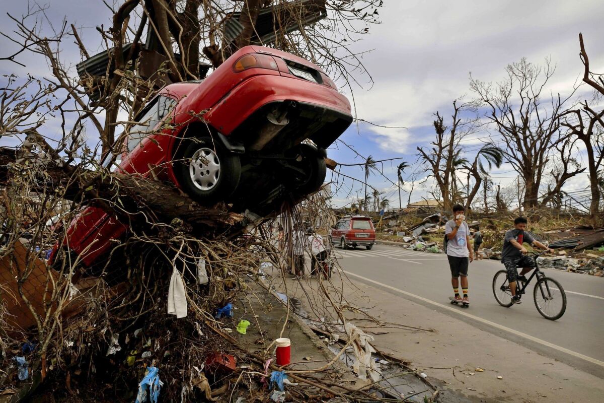 People in Tacloban, Philippines, pass scenes of devastation left by Typhoon Haiyan.