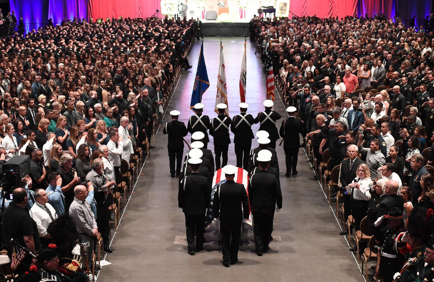 The casket of Lone Beach firefighter Capt. Dave Rosa enters the Long Beach Convention Center during his memorial service Tuesday.