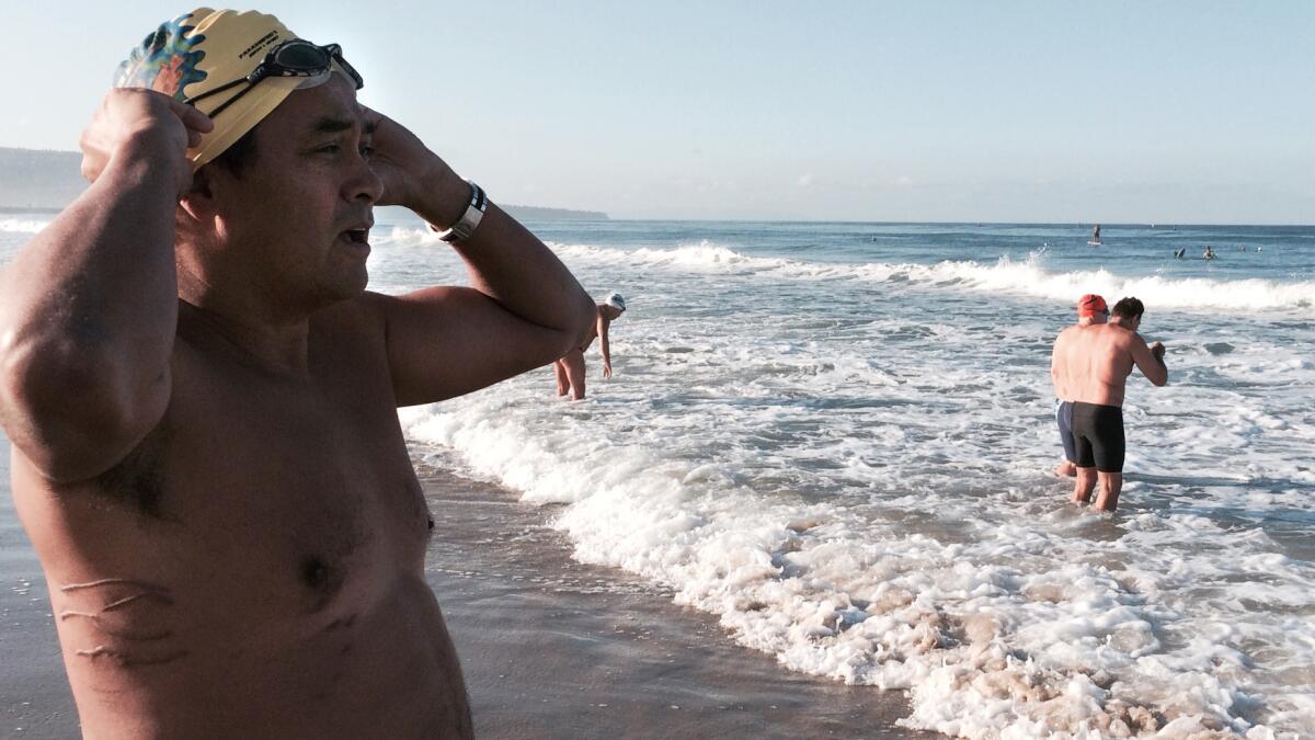 Steve Robles, wearing scars across right side from an attack by a shark in July, prepares for a pier-to-pier swim.