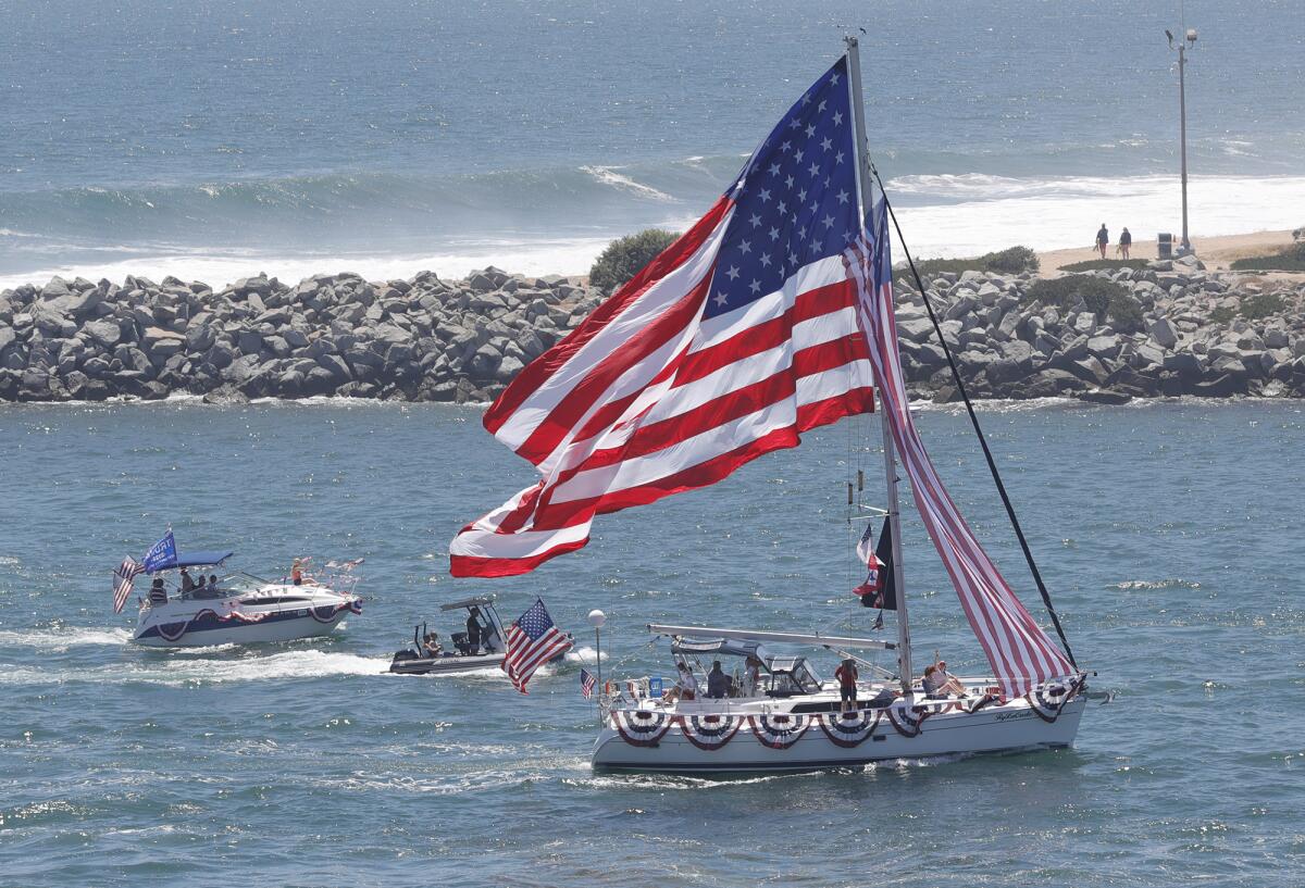 The cruiser Ry La Cade flies a boat sized American Flag during a run to the Newport Harbor entrance.