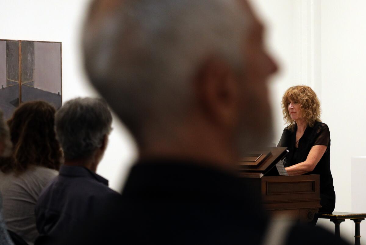 Vicki Ray, right, plays the harmonium during Monday Evening Concerts' "Music as Existential Experience" at Hauser & Wirth against a backdrop of art by Guillermo Kuitca.
