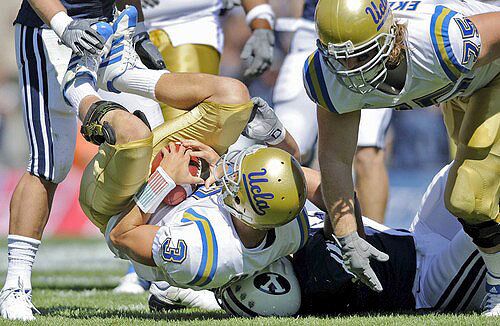 UCLA quarterback Kevin Craft is thrown to the ground by Cougars defensive lineman Ian Dulan in the second quarter Saturday.