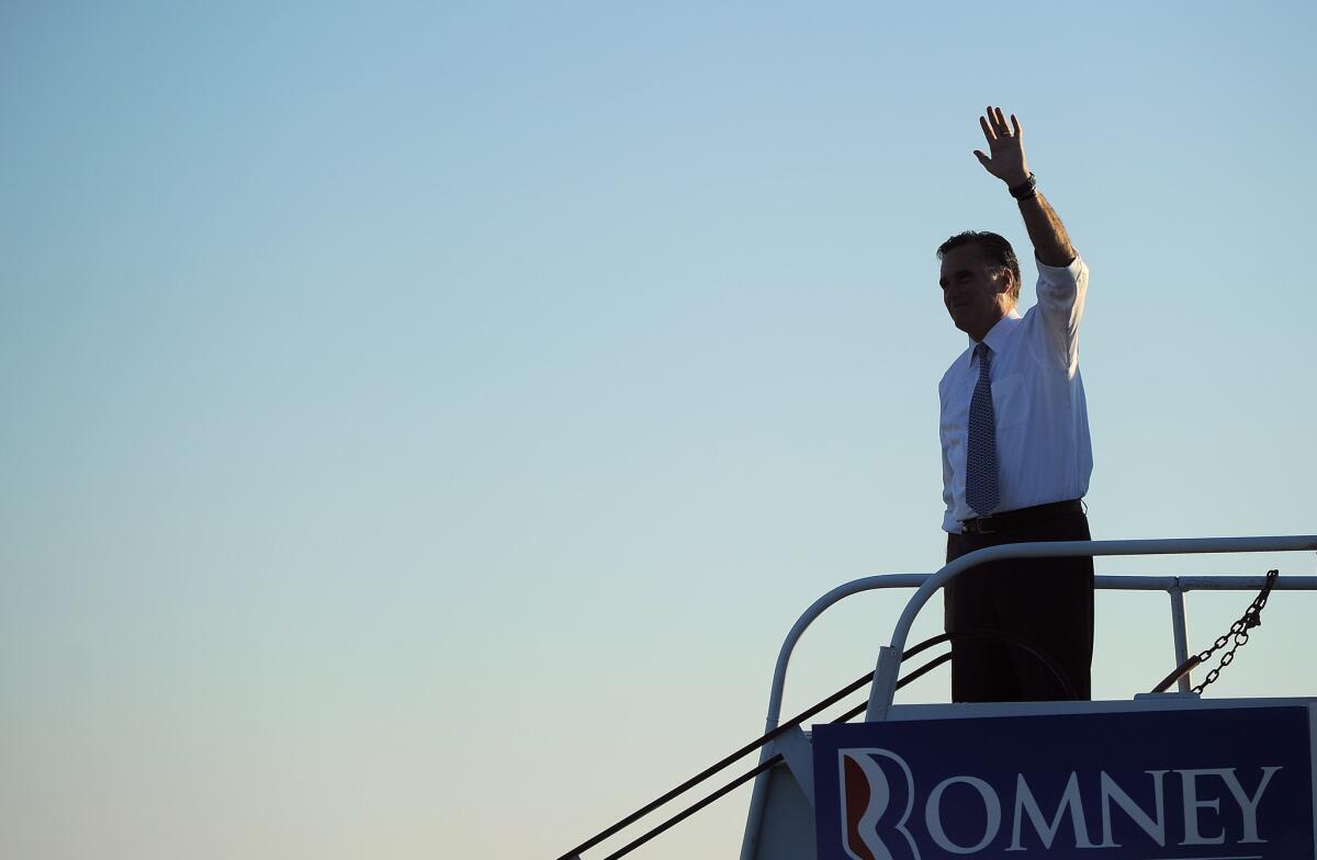 Mitt Romney waves to supporters while boarding his campaign plane in Coraopolis, Pa.