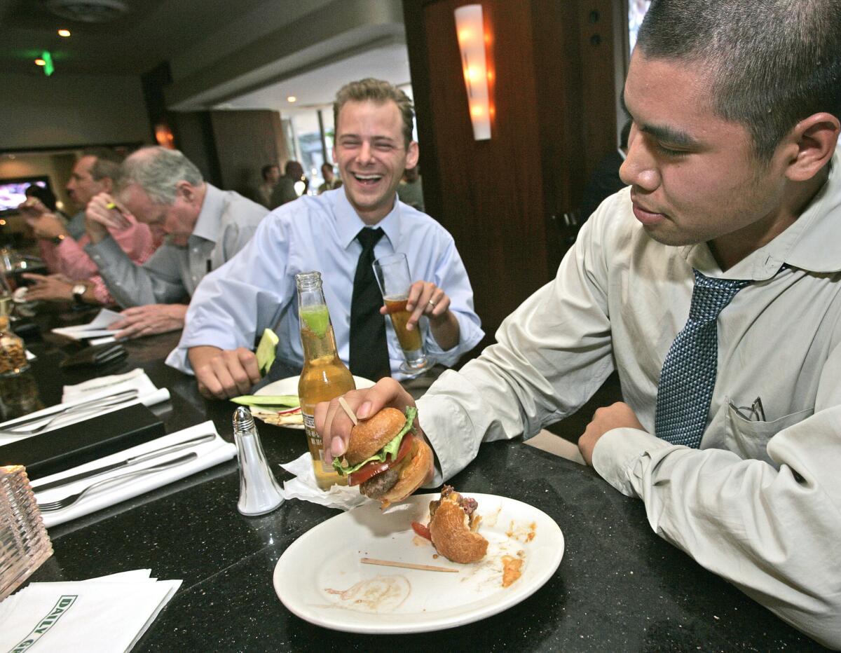 Customers eat sliders at the Daily Grill in downtown L.A. The restaurant is scheduled to close March 29 and reopen as Public School 213.