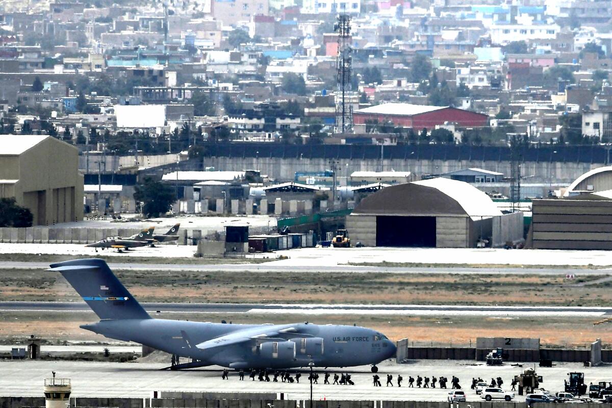 U.S. service members board an Air Force aircraft Monday at the Kabul airport.