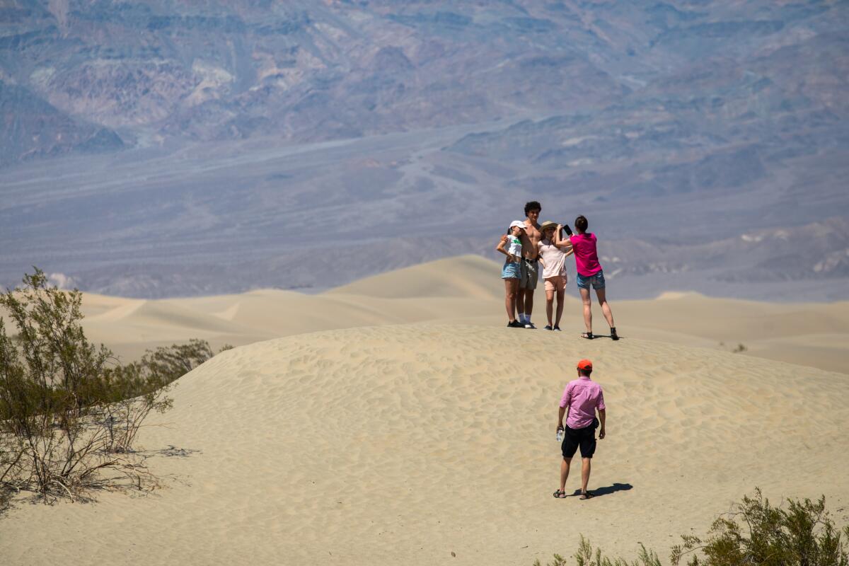 Visitors pose for photos in Mesquite Flat Sand Dunes in Death Valley.