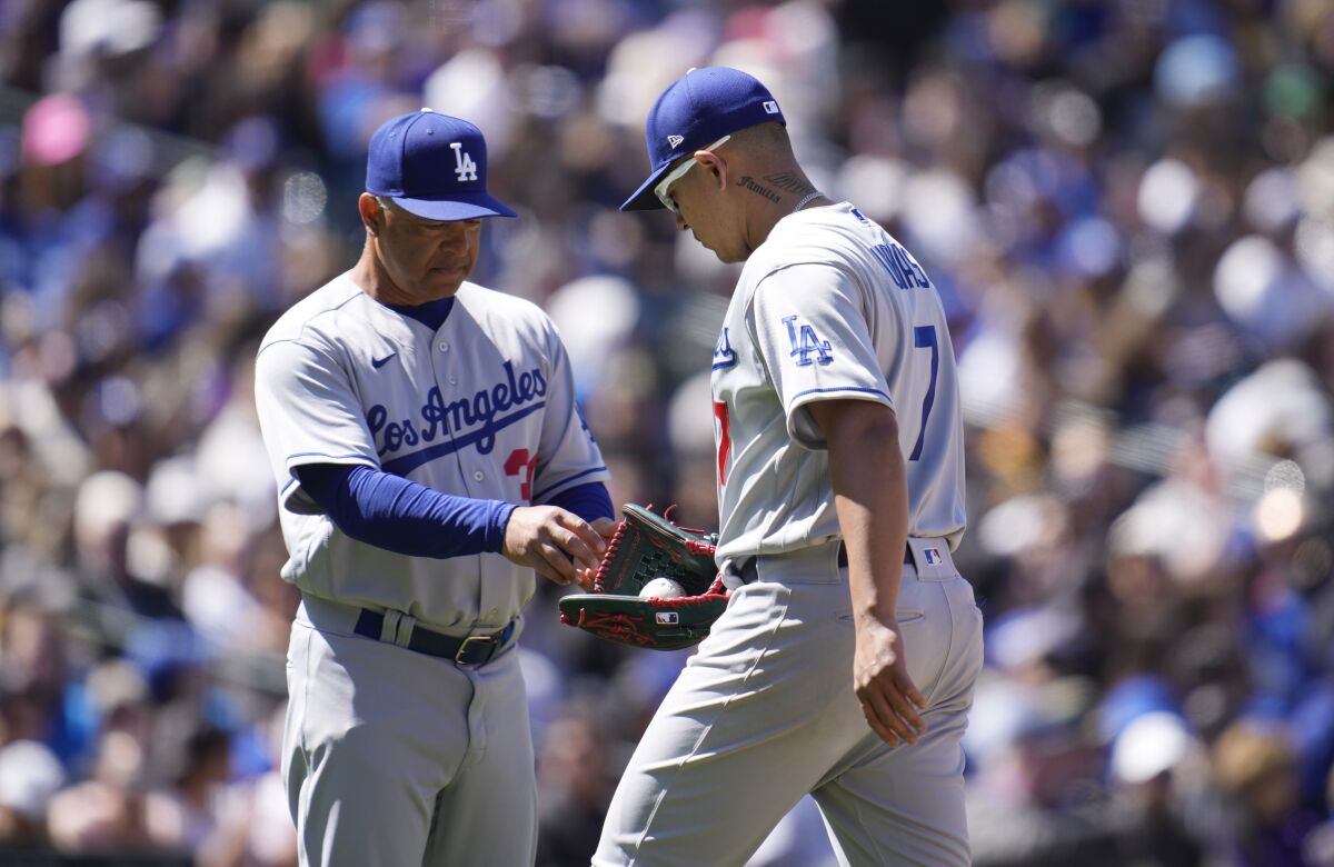 Dodgers manager Dave Roberts takes the ball from starting pitcher Julio Urías.