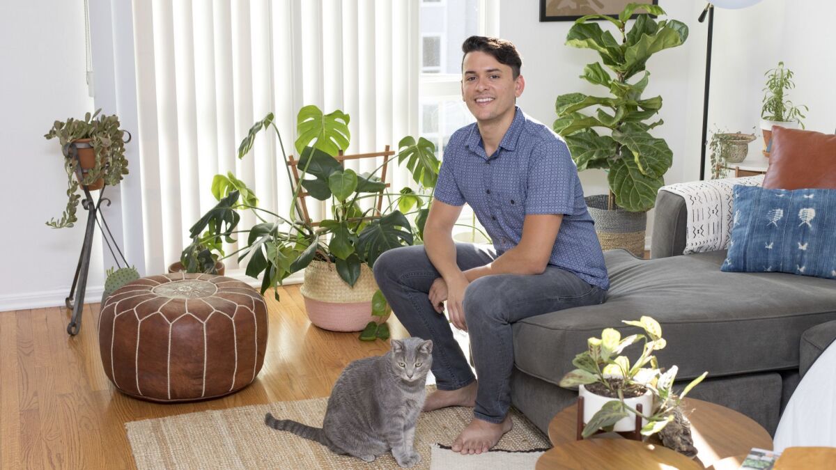 Anthony Gulino, 33, in his Los Feliz apartment with his plants and his cat Lincoln.