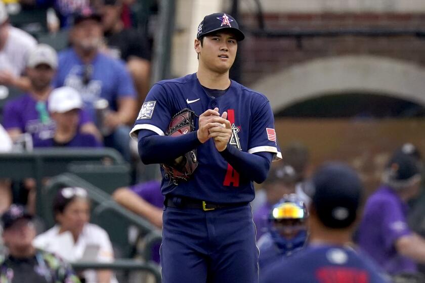American League's Shohei Ohtani, of the Los Angeles Angeles, looks to his fielders before throwing his first pitch