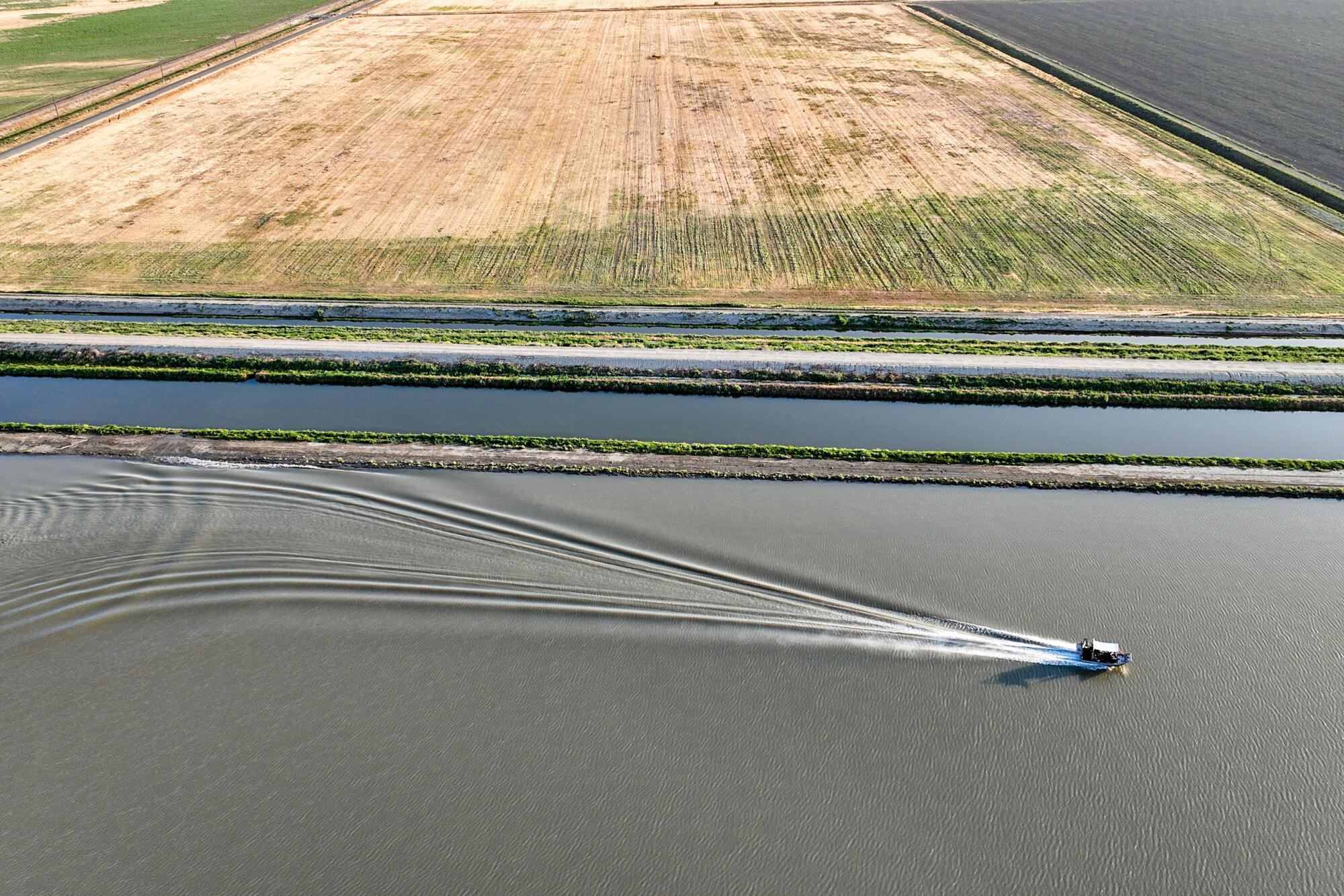 A boat skims across part of Tulare Lake next to farmland in 2023.