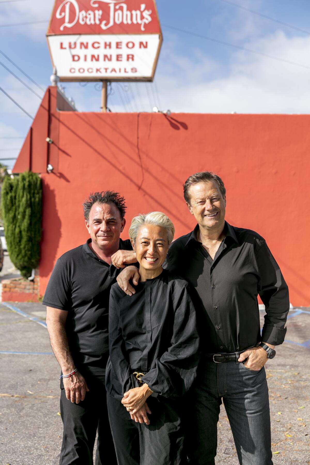 Josiah Citrin, Patti Röckenwagner and her husband, Hans Röckenwagner, pose outside of Dear John's in the daytime