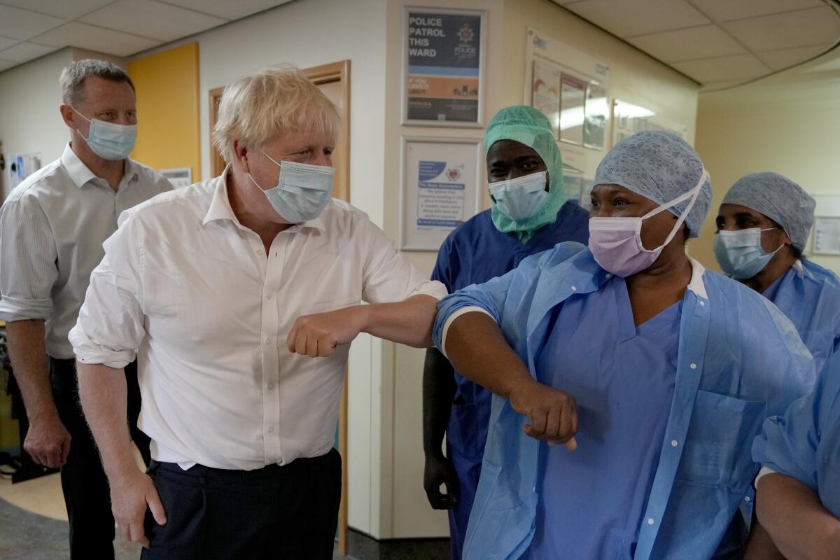 El primer ministro británico Boris Johnson saluda a trabajadores del sector salud en una visita al Centro Ortopédico South West London en Epsom, Surrey, Inglaterra, el viernes 26 de agosto de 2022. (AP Foto/Kirsty Wigglesworth, Pool)