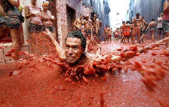 A man slides along the ground during La Tomatina festival near Valencia. Thousands of people take part in the tomato food fight each year. It began in 1945.