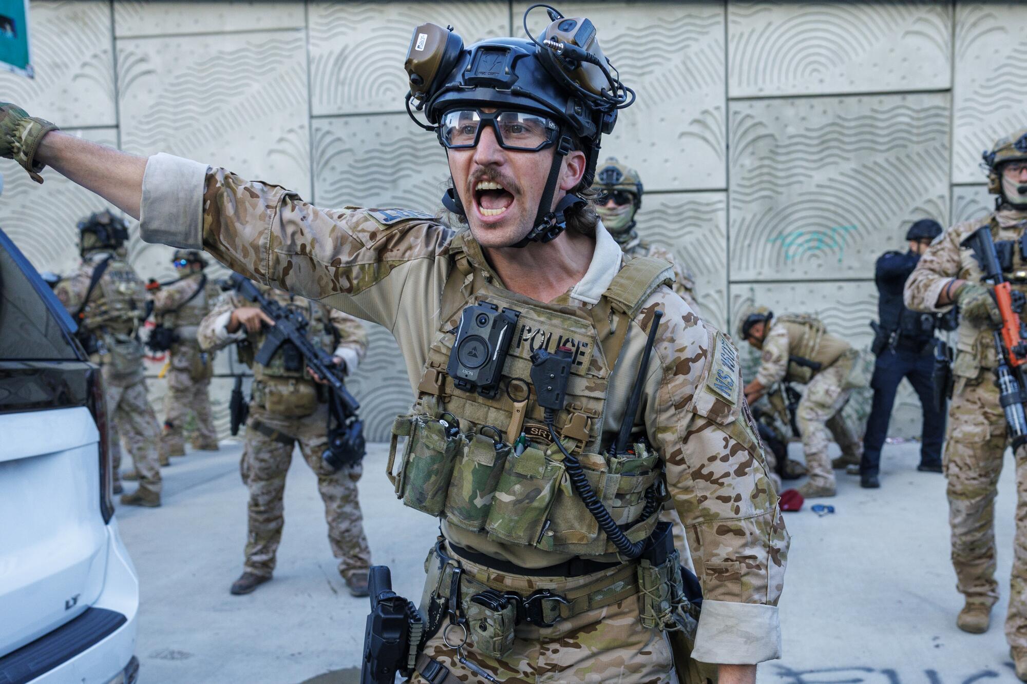 A U.S. Customs and Border Protection officer shouting and gesturing at protesters