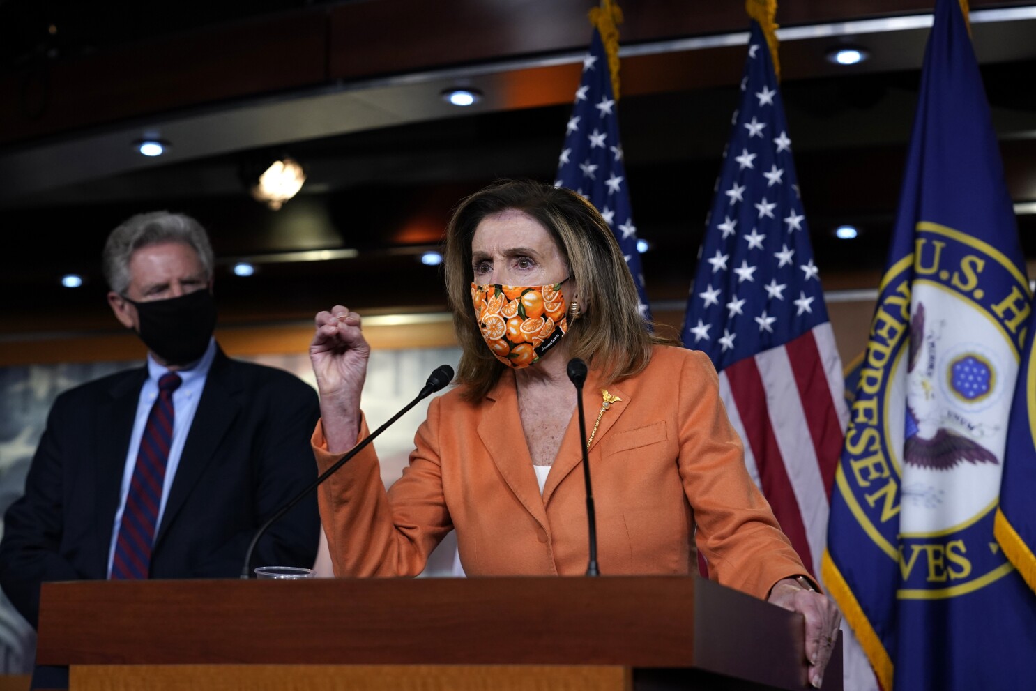 Congresswoman speaking at podium with mask on