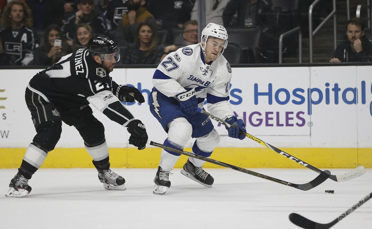 Kings defenseman Alec Martinez, left, goes after the puck against Tampa Bay left wing Jonathan Drouin on Jan. 16.