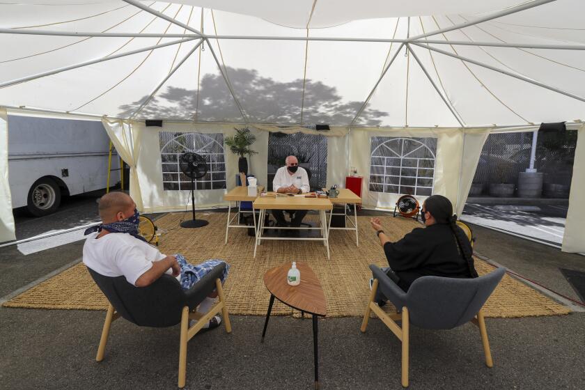 LOS ANGELES, CA -AUGUST06: Fr. Greg Boyle, center, of Homeboy Industries is running the operation from a tent in the parking lot. Homeboy Industries was on brink of budget disaster, then Fr. Boyle just won a $3.5 million humanitarian award, mana from heaven. Homeboy Industries on Thursday, Aug. 6, 2020 in Los Angeles, CA. (Irfan Khan/Los Angeles Times)