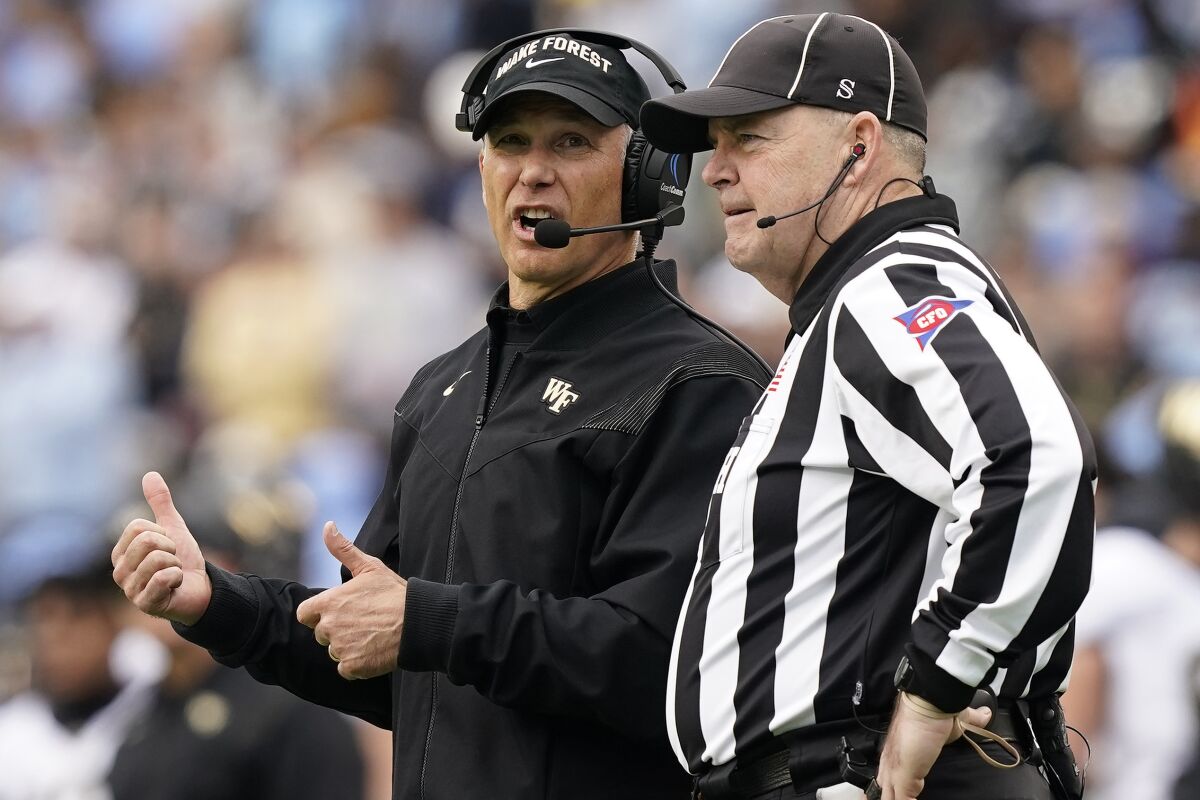 Wake Forest head coach Dave Clawson speaks with an official during the second half of an NCAA college football game against North Carolina in Chapel Hill, N.C., Saturday, Nov. 6, 2021. (AP Photo/Gerry Broome)