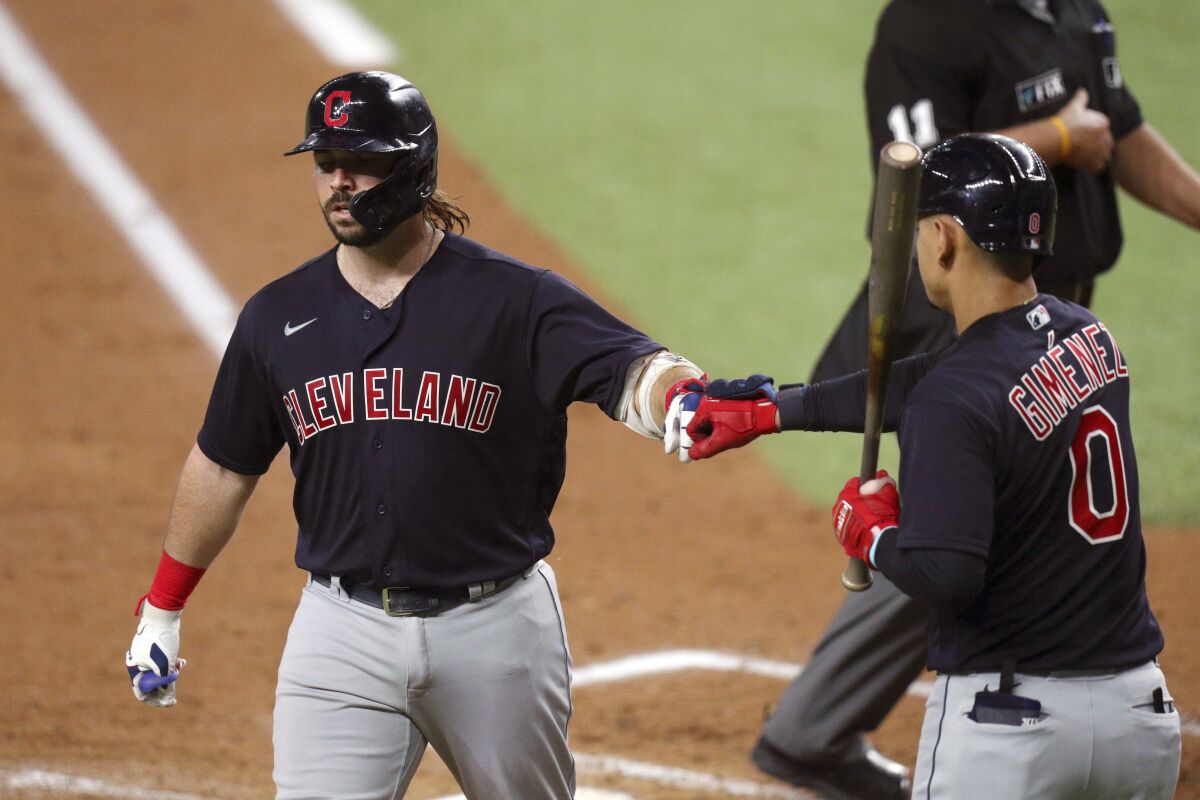 Cleveland Indians Austin Hedges (17) is greeted by Andres Gimenez (0) after scoring on a solo home run against the Texas Rangers in the third inning of a baseball game Friday, Oct. 1, 2021, in Fort Worth, Texas. (AP Photo/Richard W. Rodriguez)