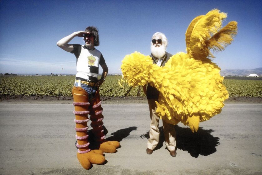 Caroll Spinney, left, prepares to don Big Bird’s yellow-feathered costume with help of Kermit Love.