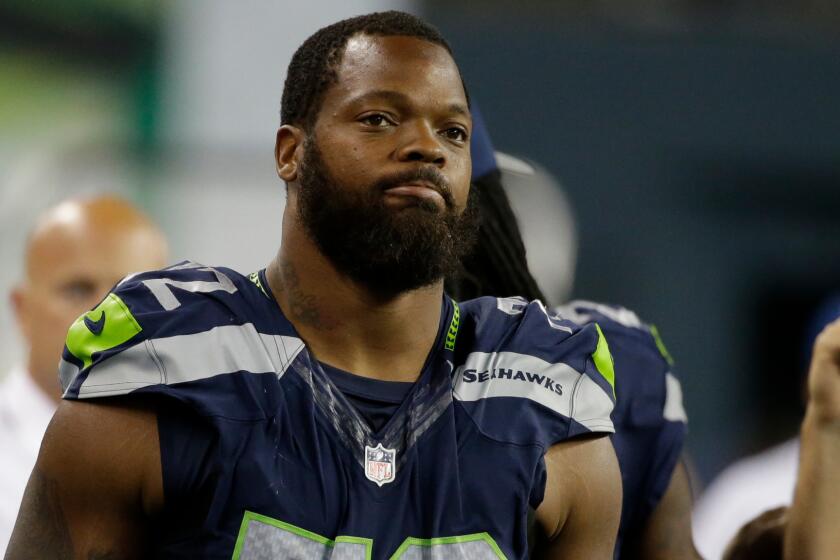 Seattle's Michael Bennett stands on the sidelines on Aug. 25.