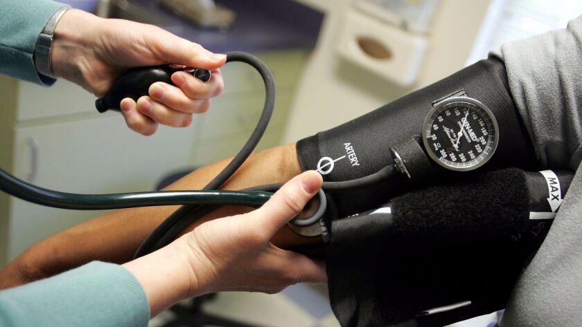 A doctor checks a patient's blood pressure. A new survey of primary care physicians finds widespread support for many of the Affordable Care Act's signature provisions.