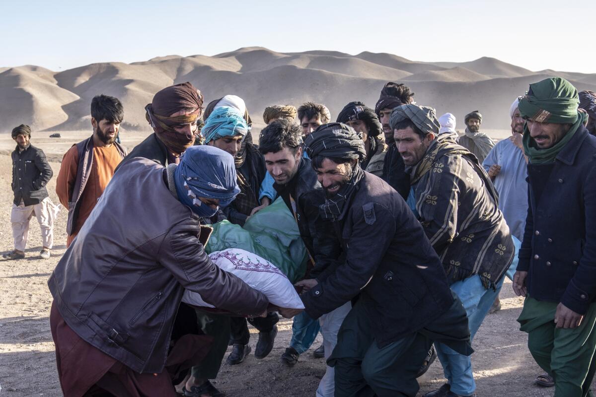 Afghan people carry the body of a relative killed in an earthquake 