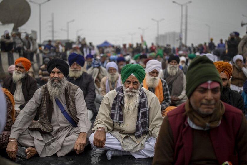 Farmers listen to a speaker as they block a major highway in protest against new farm laws, at the Delhi-Uttar Pradesh state border, India, Friday, Jan. 8, 2021. (AP Photo/Altaf Qadri)