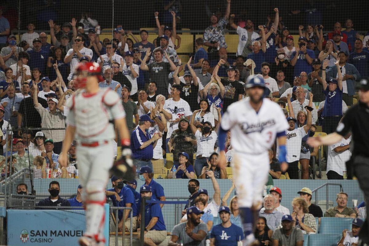 Fans cheer as Dodgers left fielder Chris Taylor scores on a double by pitcher Julio Urias.