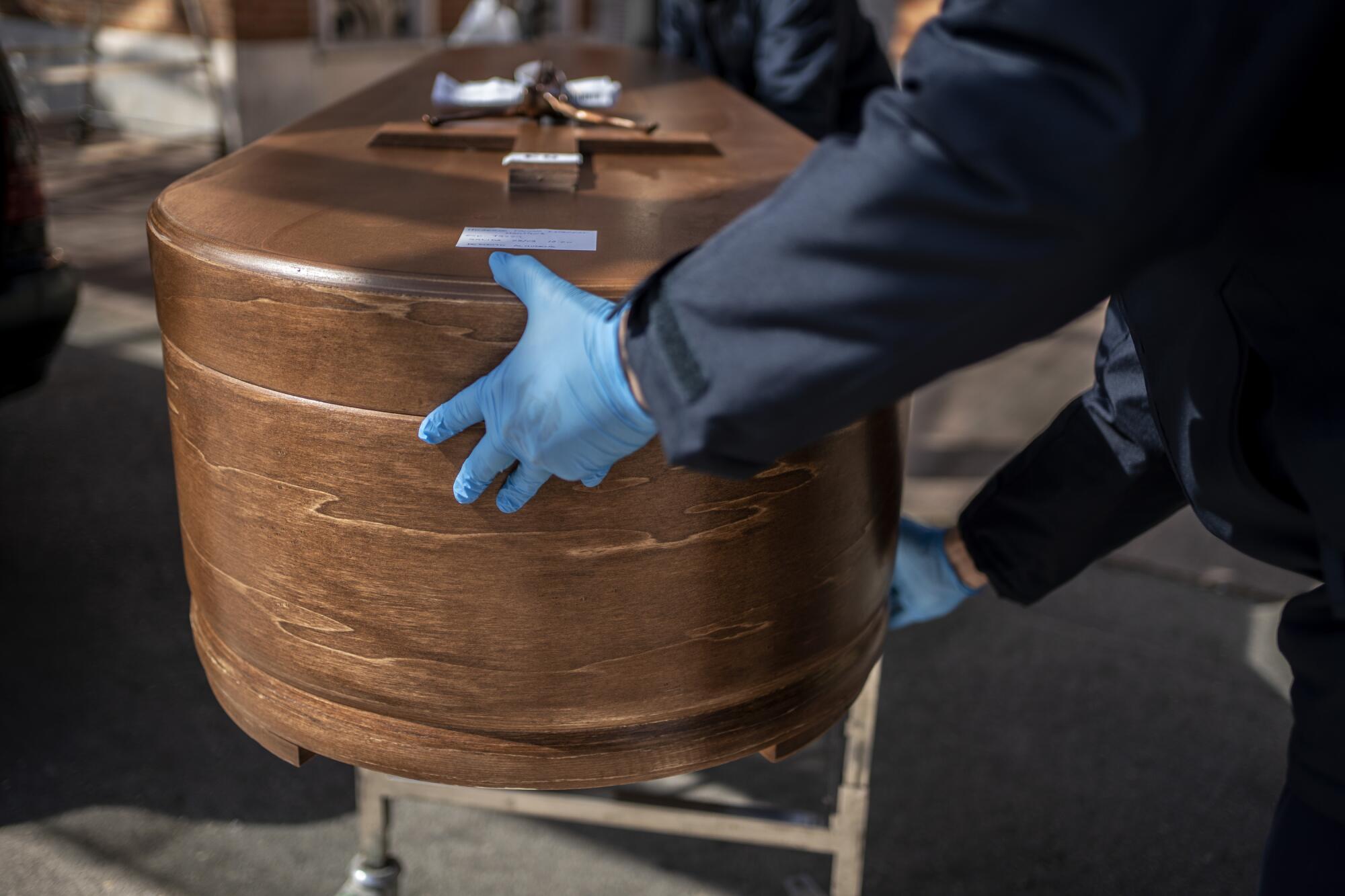 SPAIN:  The coffin containing remains of a COVID-19 victim is carried at the Almudena cemetery in Madrid.