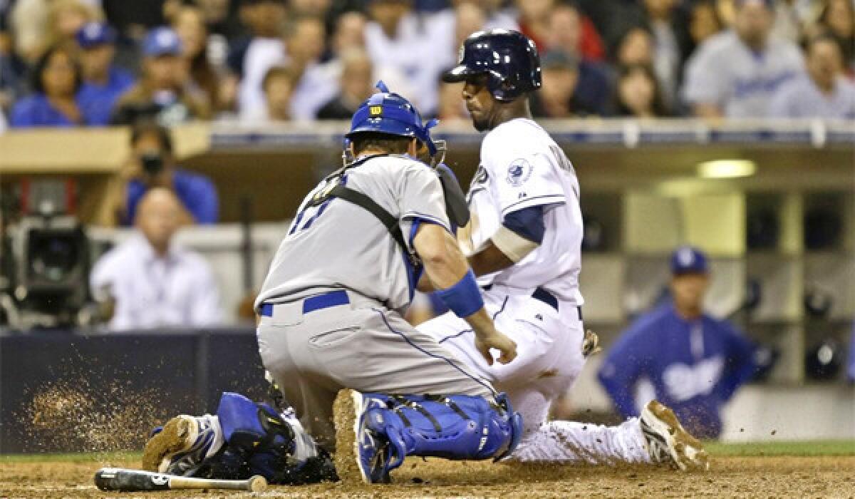 A.J. Ellis tags out Pedro Ciriaco at the plate during the Dodgers' loss to the San Diego Padres, 6-3.