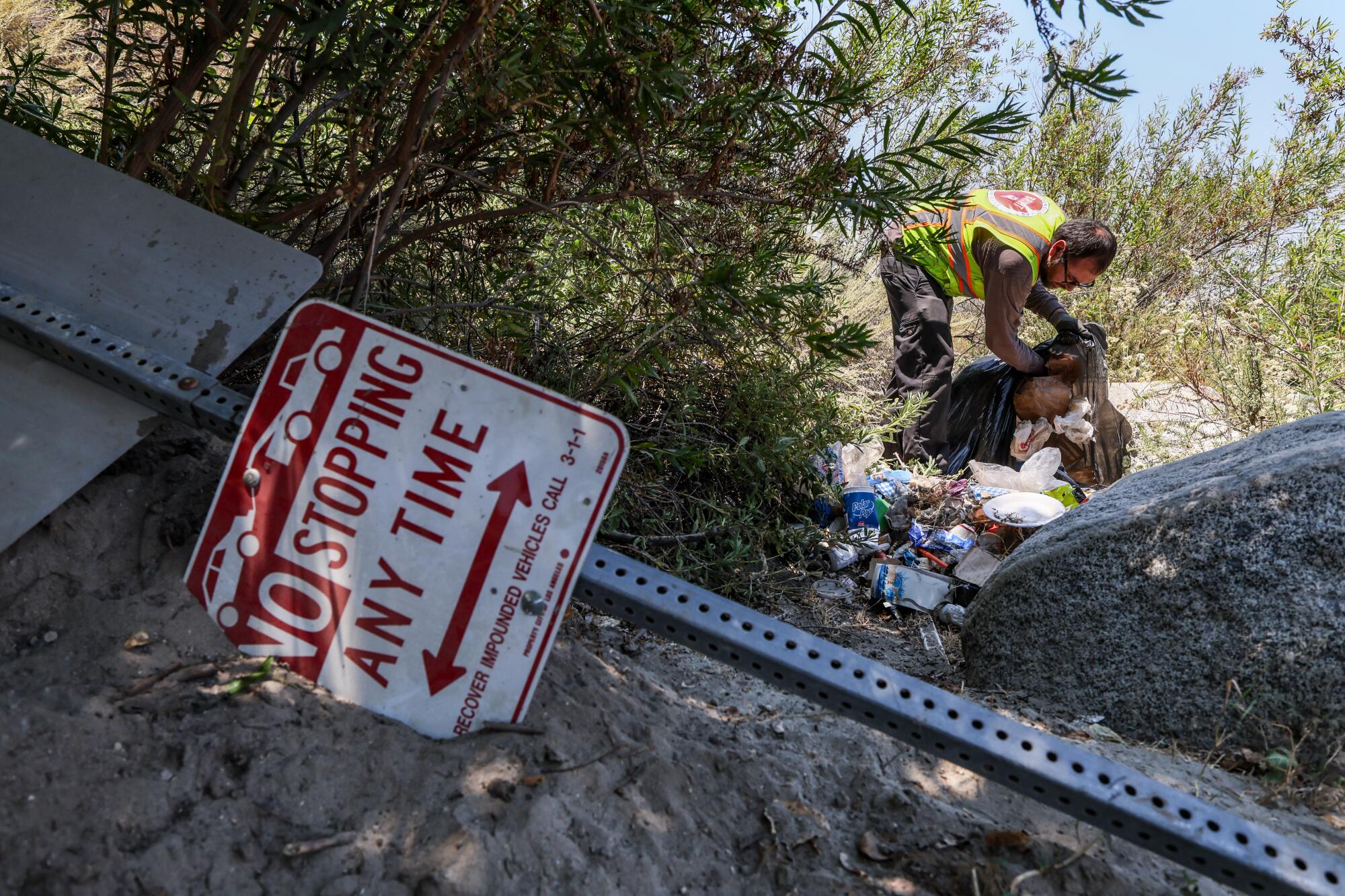 Lonzo Medina of Northeast Graffiti Busters picks up trash along the Tujunga Wash for Operation Bright Spot.