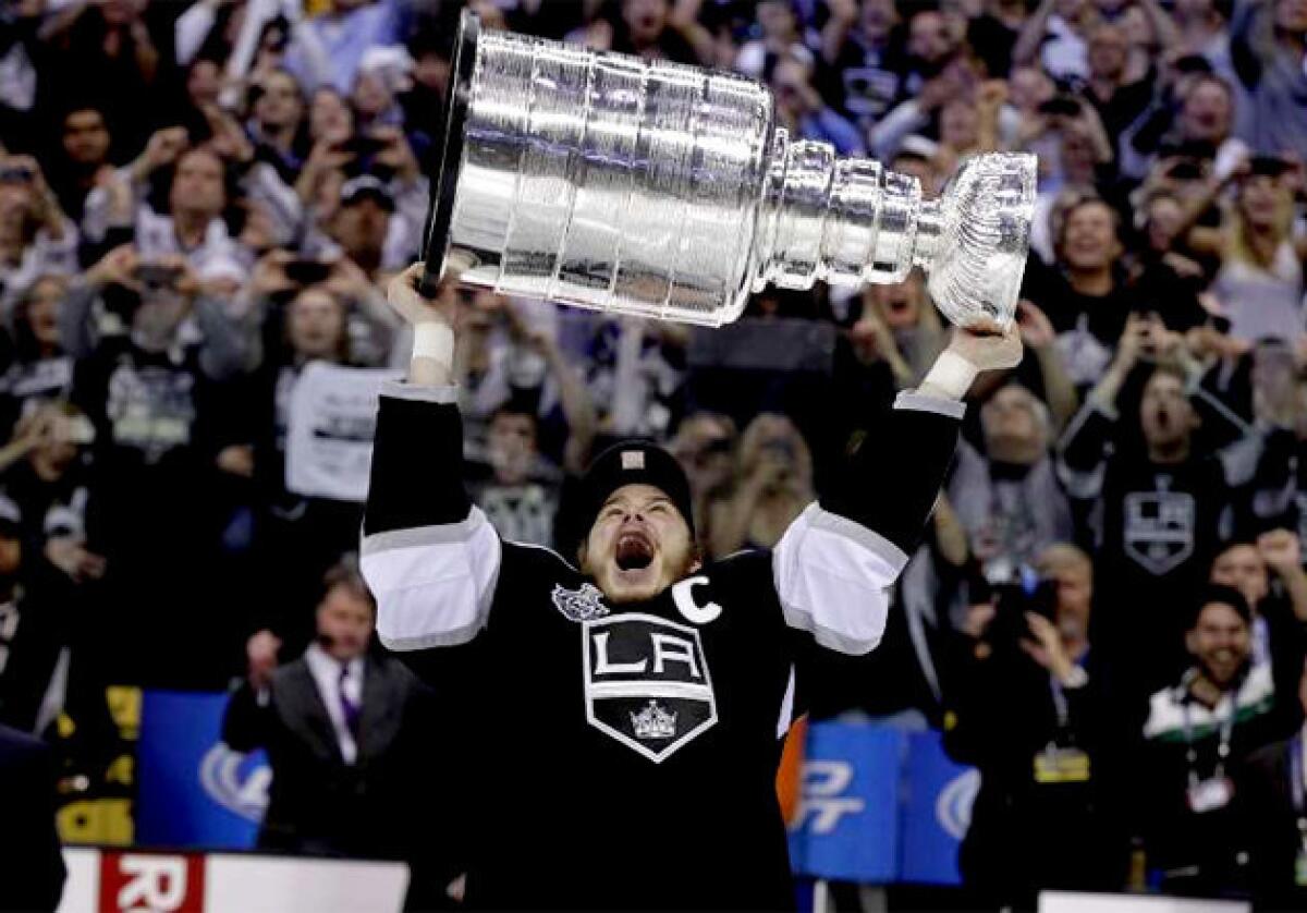 Los Angeles Kings' Dustin Brown hoists the Stanley Cup last June.