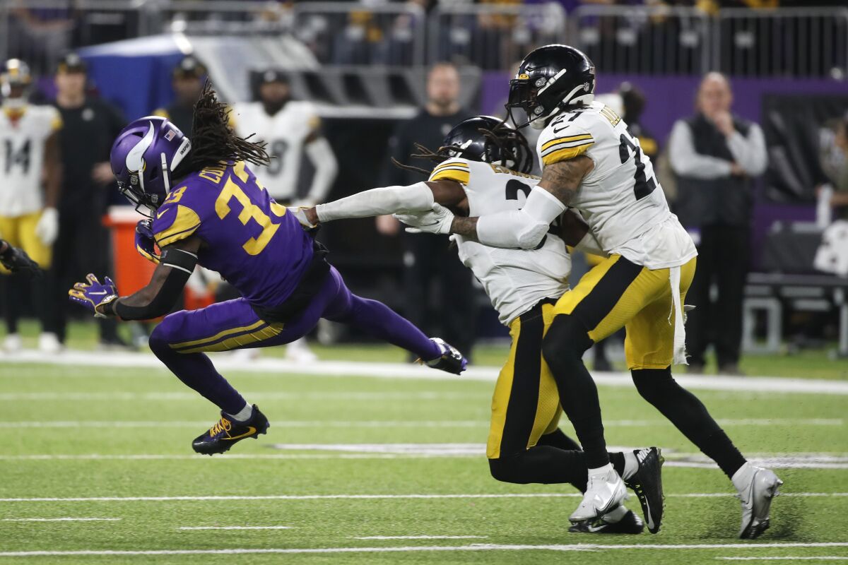 Minnesota Vikings running back Dalvin Cook (33) runs from Pittsburgh Steelers safety Terrell Edmunds and linebacker Marcus Allen, right, after catching a pass during the second half of an NFL football game, Thursday, Dec. 9, 2021, in Minneapolis. The Vikings won 36-28. (AP Photo/Bruce Kluckhohn)
