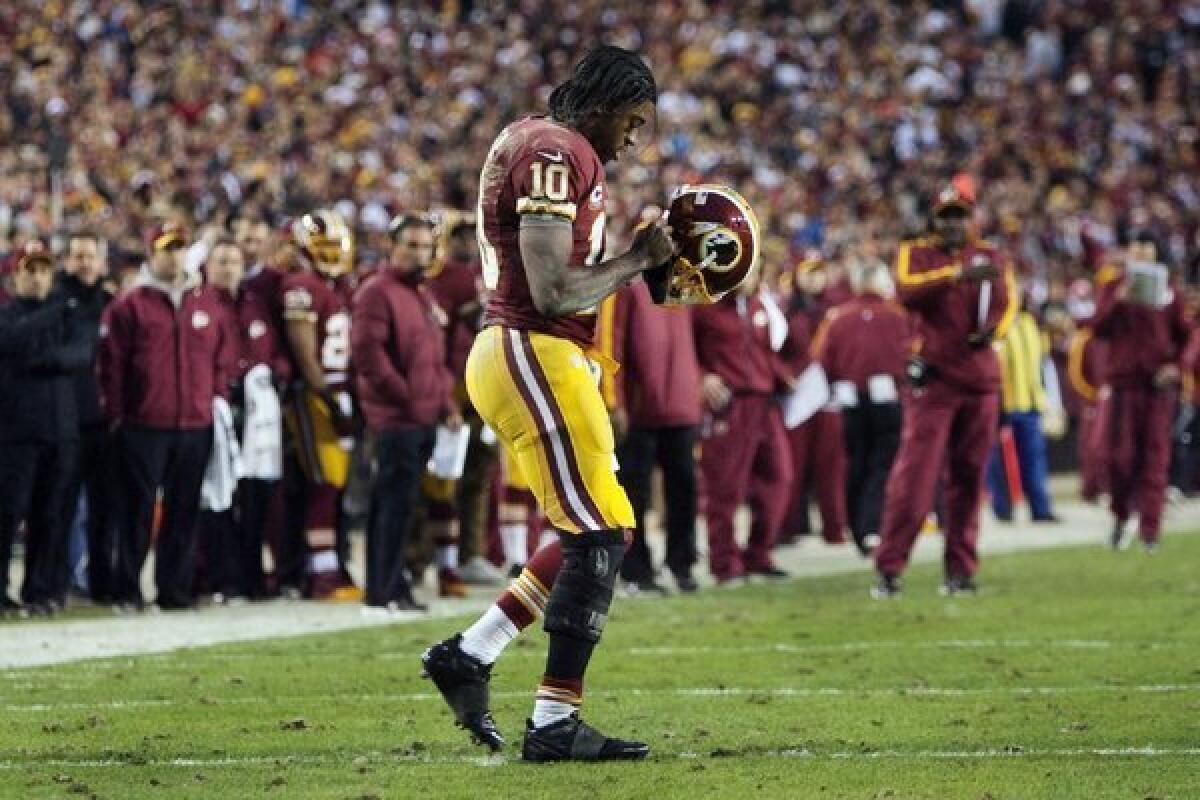 Robert Griffin III walks back to the huddle during Sunday's game against Seattle.