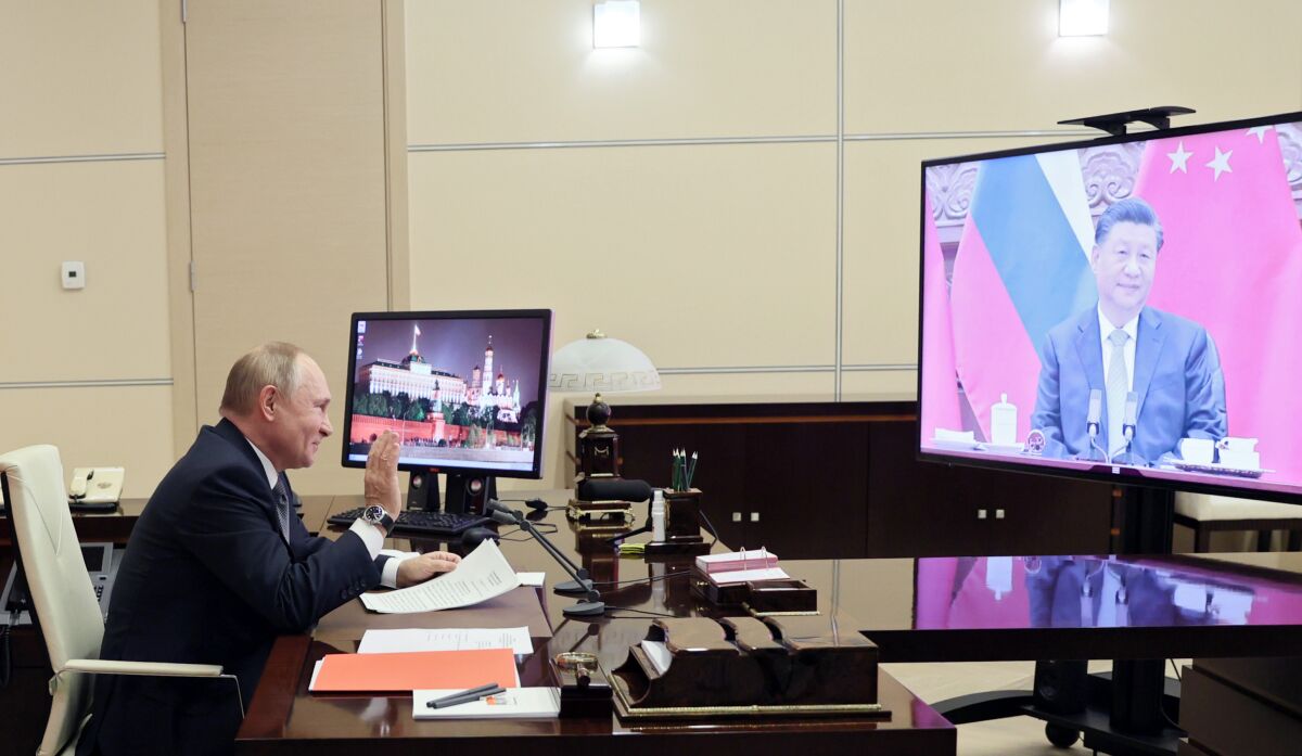 Russian President Vladimir Putin gestures during his videoconference with Chinese President Xi Jinping, right on the screen, in Moscow, Russia, Wednesday, Dec. 15, 2021. Russian President Vladimir Putin and Chinese leader Xi Jinping have held a video call to discuss bilateral relations and international affairs. The summit Wednesday comes amid heightened tensions between Moscow and the West over a Russian troop buildup near Ukrainian borders that is stoking fears of a possible invasion. (Mikhail Metzel, Sputnik, Kremlin Pool Photo via AP)