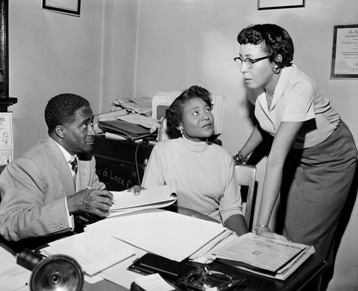 FILE - This file photo shows Autherine Lucy Foster, center, the first Black person to attend University of Alabama, discussing her return to campus following mob demonstrations in Birmingham, Ala., on Feb. 7, 1956. She held a press conference accompanied by Ruby Hurley, right, Southeast regional secretary of the NAACP, and attorney Arthur Shores, left. The school in 2022 decided to add Foster's name to a building already named for a KKK leader and former governor. (AP Photo/Gene Herrick)