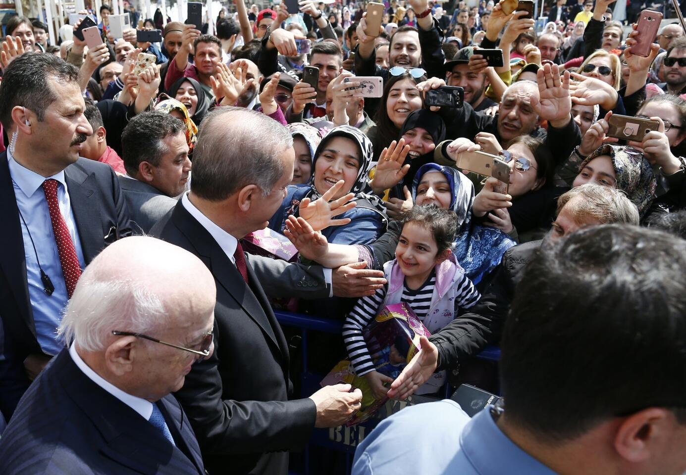 Turkish President Recep Tayyip Erdogan greets a girl in a crowd after praying at Eyup Sultan mosque, Istanbul, Turkey.
