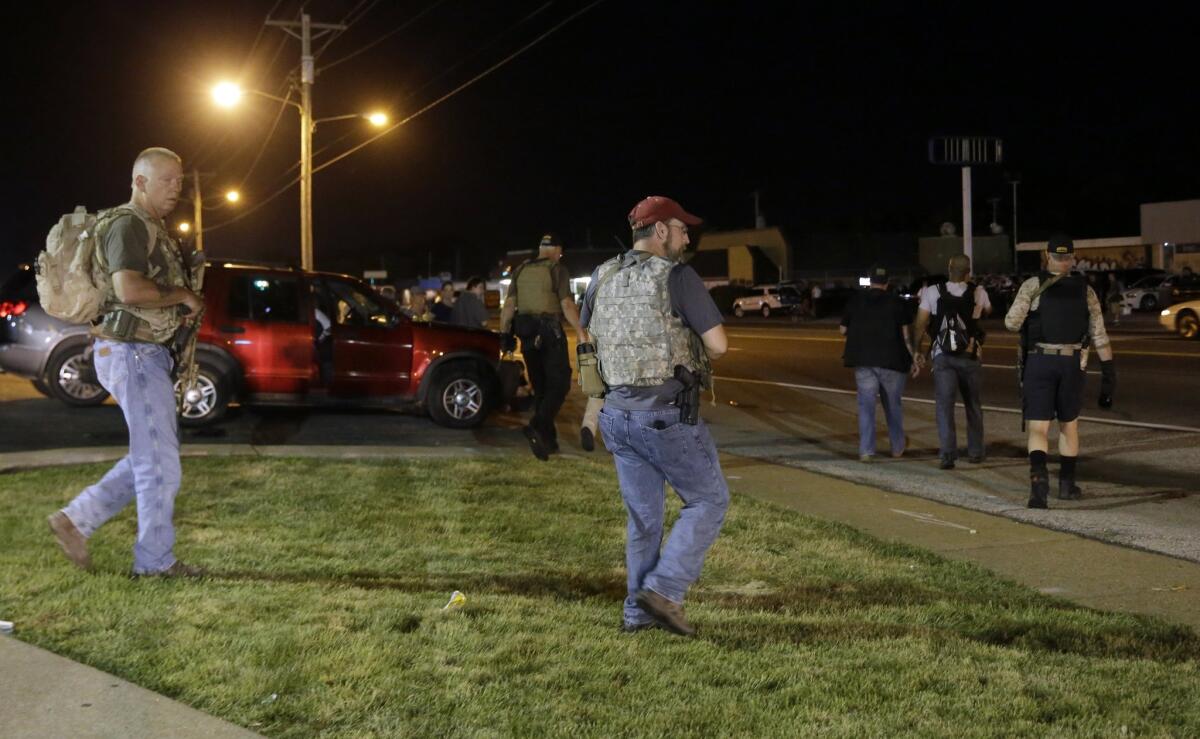 Heavily armed civilians with an anti-government group called the Oath Keepers patrol in Ferguson, Mo., (Jeff Roberson / Associated Press)