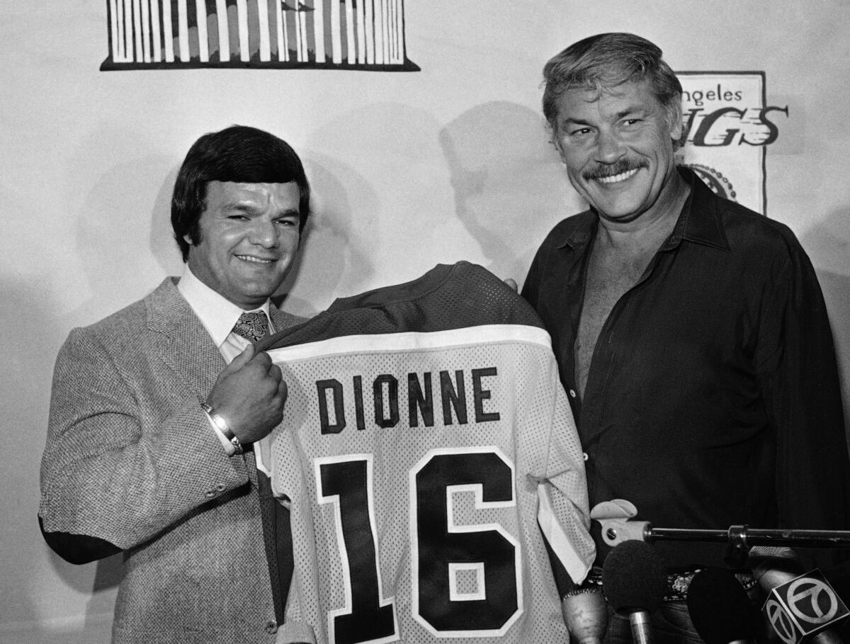 Kings center Marcel Dionne holds his Kings jersew with owner Dr. Jerry Buss at a news conference on Aug. 21, 1980. Dionne will be on hand to celebrate the Kings' 50th anniversary in Los Angeles on Tuesday.